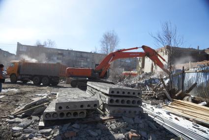 Екатеринбург. Принудительный снос незаконно построенного многоквартирного дома на земле для индивидуального строительства. Экскаватор собирает строительный мусор.