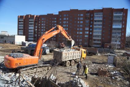 Екатеринбург. Принудительный снос незаконно построенного многоквартирного дома на земле для индивидуального строительства. Экскаватор собирает строительный мусор.