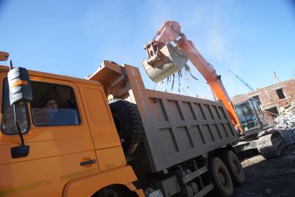 Екатеринбург. Принудительный снос незаконно построенного многоквартирного дома на земле для индивидуального строительства. Экскаватор собирает строительный мусор.