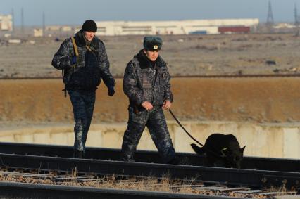 Космодром `Байконур`. Полицейские с собакой осматривают пути.