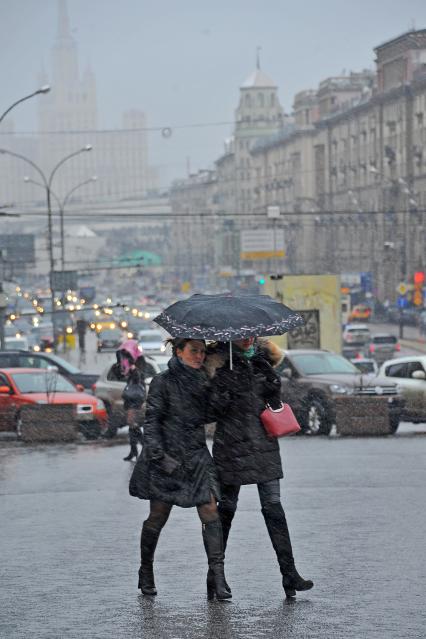 Снегопад в Москве.  Девушки идут под зонтом.