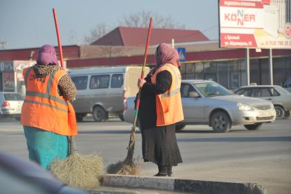 Грозный. Женщины в оранжевых жилетах подметают дорогу.