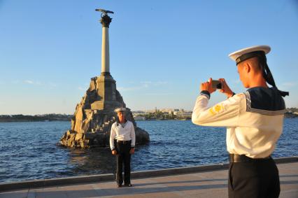 Севастополь. Учащиеся военно-морского училища имени П.С.Нахимова фотографируются на фоне памятника  затопленным кораблям.