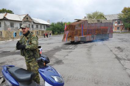 Украина. Донецкая область. п.Коммунар. Ополченец у бронемашины с надписью `4 рота Рэкс` на площади.