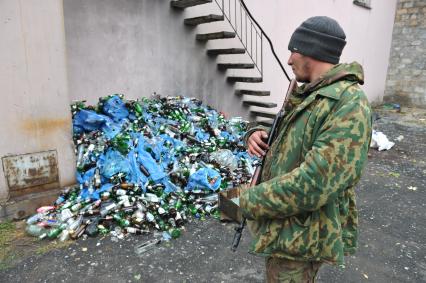 Украина. Донецкая область. п.Коммунар. Ополченец показывает пустые бутылки, оставленные украинскими военными.