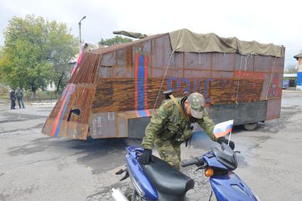 Украина. Донецкая область. п.Коммунар. Ополченец у бронемашины с надписью `4 рота Рэкс` на площади.