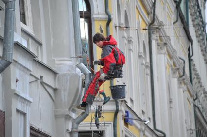 Промышленный альпинист на здании в районе улицы Ильинка в Москве.