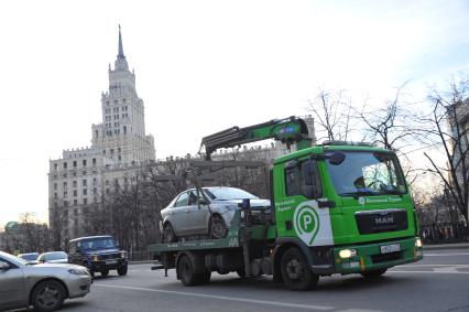 Москва. `Зеленый` эвакуатор перевозит автомобиль у метро `Красные Ворота`.