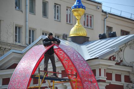 Подготвка к пасхе в Москве. У станции метро `Новокузнецкая` рабочие устанавливают 6-метровый кулич из пластика.