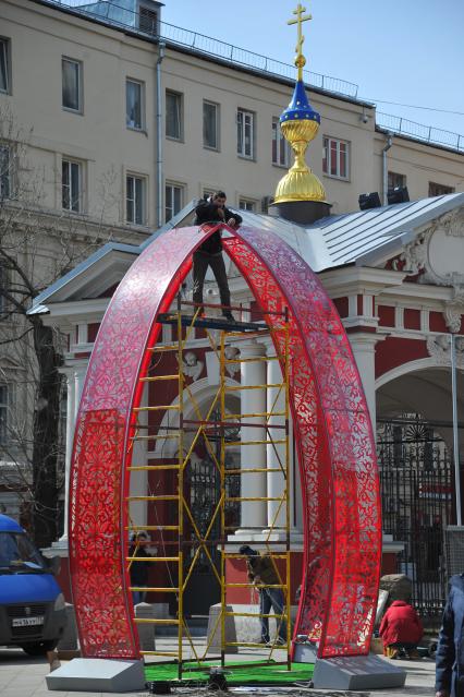 Подготвка к пасхе в Москве. У станции метро `Новокузнецкая` рабочие устанавливают 6-метровый кулич из пластика.