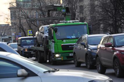 Москва. `Зеленый` эвакуатор перевозит автомобиль у метро `Красные Ворота`.