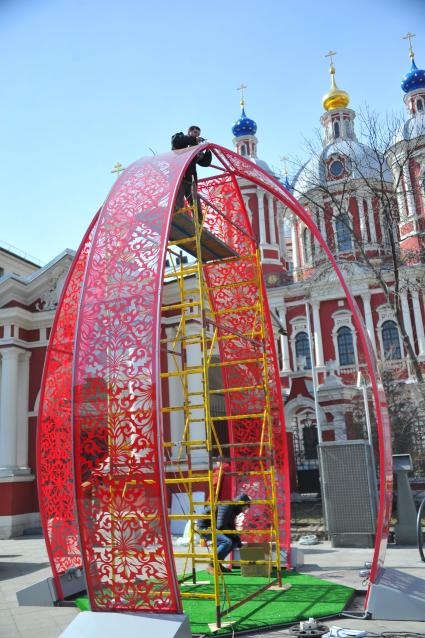 Подготвка к пасхе в Москве. У станции метро `Новокузнецкая` рабочие устанавливают 6-метровый кулич из пластика.