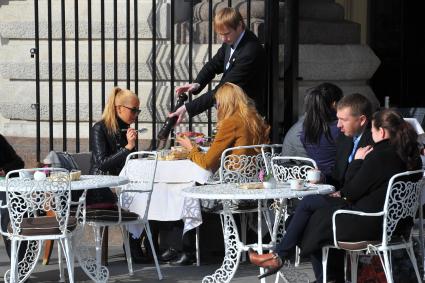 Москва. Девушки обедают в летнем кафе у Красной площади.