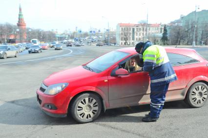 Москва. Сотрудник ГИБДД проверяет документы у девушки- водителя на Боровицкой площади.