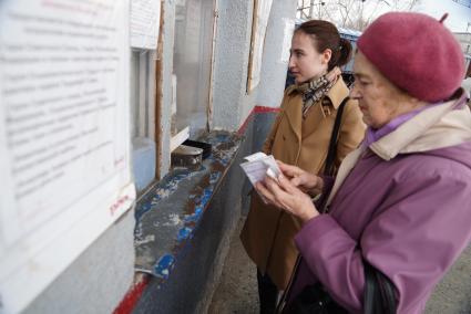 Екатеринбург. Женщина покупает билет на электричку в кассе РЖД.