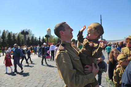 Москва. Мужчина с ребенком на руках в военной форме времен ВОВ во время праздничных мероприятий, посвященных 69-й годовщине Победы в Великой Отечественной войне на Поклонной горе.