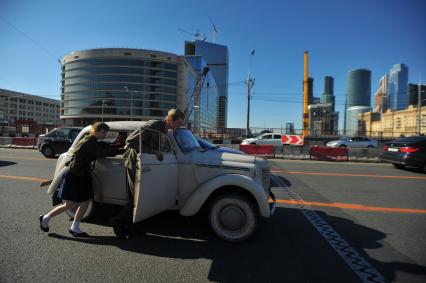 Москва. Молодые люди в военной форме времен ВОВ толкают ретро-автомобиль по Дорогомиловскому мосту во время праздничных мероприятий, посвященных 69-й годовщине Победы в Великой Отечественной войне на Поклонной горе.