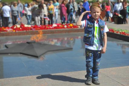 Москва. Мальчик отдает честь перед Вечным огнем во время праздничных мероприятий, посвященных 69-й годовщине Победы в Великой Отечественной войне на Поклонной горе.