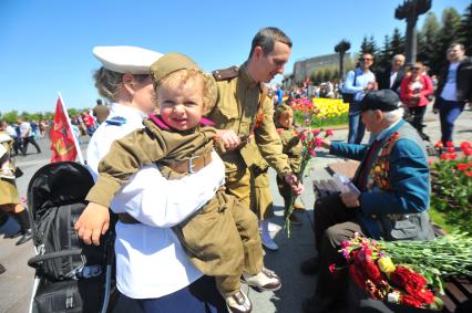 Москва. Мужчина в военной форме времен ВОВ дарит цветы ветерану во время праздничных мероприятий, посвященных 69-й годовщине Победы в Великой Отечественной войне на Поклонной горе.