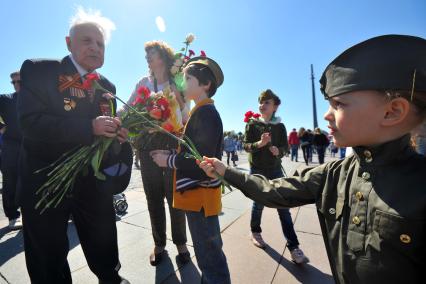 Москва. Девочка дарит цветы ветерану во время праздничных мероприятий, посвященных 69-й годовщине Победы в Великой Отечественной войне на Поклонной горе.