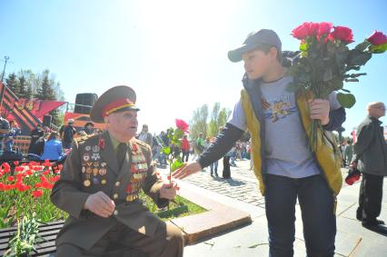 Москва. Мальчик дарит цветы ветерану во время праздничных мероприятий, посвященных 69-й годовщине Победы в Великой Отечественной войне на Поклонной горе.