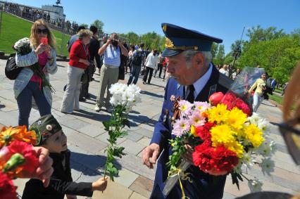 Москва. Мальчик дарит цветы ветерану во время праздничных мероприятий, посвященных 69-й годовщине Победы в Великой Отечественной войне на Поклонной горе.