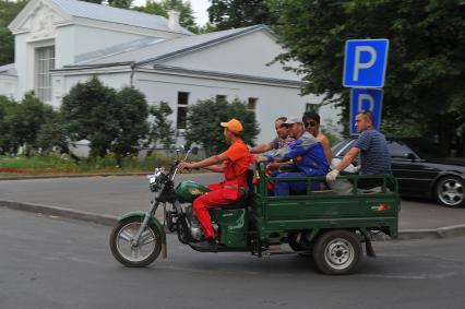 Москва. ВДНХ. Рабочие едут на грузовом мотоцикле с прицепом.