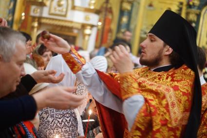 Священник раздает прихожанам пасхальные яйца во время Пасхальной службы в Свято-Троицком соборе. Екатеринбург