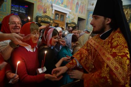 Священник раздает прихожанам пасхальные яйца во время Пасхальной службы в Свято-Троицком соборе. Екатеринбург