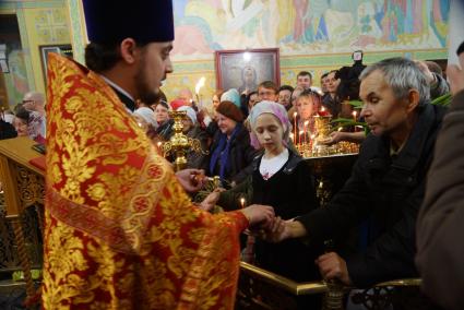 Священник раздает прихожанам пасхальные яйца во время Пасхальной службы в Свято-Троицком соборе. Екатеринбург