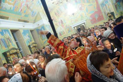 Священник бросает пасхальные яйца православному хору, на балкон второго этажа Свято-Троицкого собора во время Пасхальной службы. Екатеринбург