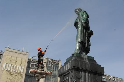 Сотрудники коммунальной службы моют памятник  А.С. Пушкину на Пушкинской площади в Москве.