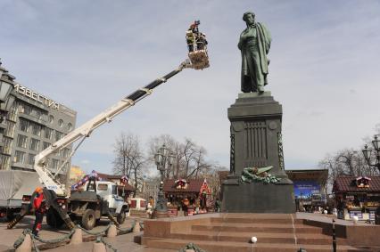 Сотрудники коммунальной службы моют памятник  А.С. Пушкину на Пушкинской площади в Москве.