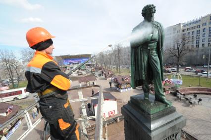 Сотрудники коммунальной службы моют памятник  А.С. Пушкину на Пушкинской площади в Москве.