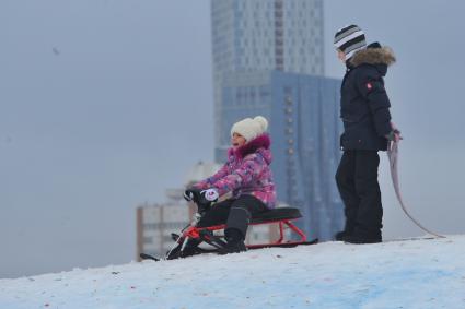 Москва. Девочка с санками на снежной горке в Парке Победы.