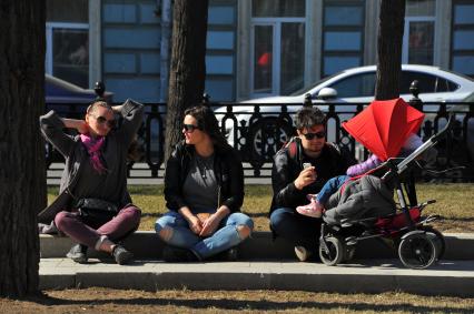 Люди отдыхают на газоне на Никитском бульваре в Москве.