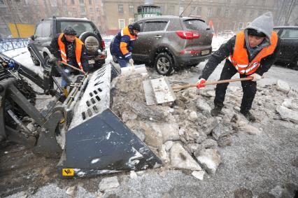 Москва. Дворники ГБУ `Жилищник` района Покровское-Стрешнево убирают сбитую наледь с асфальта.