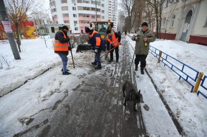 Москва. Дворники ГБУ `Жилищник` района Покровское-Стрешнево убирают сбитую наледь с асфальта.