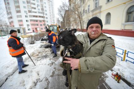 Москва. Дворники ГБУ `Жилищник` района Покровское-Стрешнево убирают сбитую наледь с асфальта.