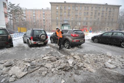 Москва. Дворник ГБУ `Жилищник` района Покровское-Стрешнево убирает лопатой сбитую наледь с асфальта.