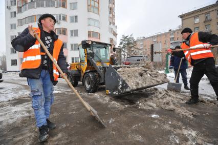 Москва. Дворники ГБУ `Жилищник` района Покровское-Стрешнево убирают сбитую наледь с асфальта.