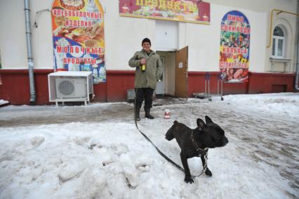 Москва. Мужчина выгуливает собаку.