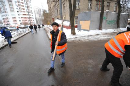 Москва. Дворник ГБУ `Жилищник` района Покровское-Стрешнево убирает лопатой сбитую наледь с асфальта.