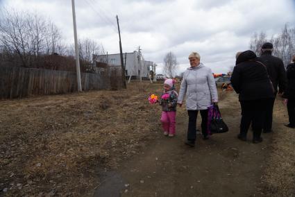 Женщина с ребенком идут к  могиле своих родственников. Родительский день. Нижнеисетское кладбище. Екатеринбург