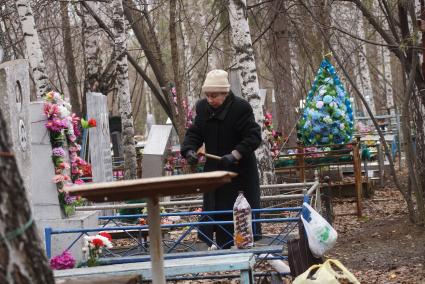 Женщина прибирается на могиле своих родственников. Родительский день. Нижнеисетское кладбище. Екатеринбург