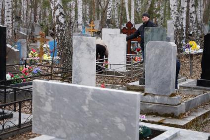 Люди прибираются на могиле своих родственников. Родительский день. Нижнеисетское кладбище. Екатеринбург