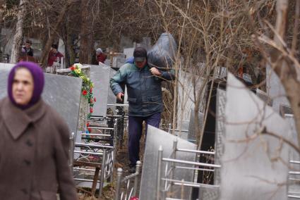 Люди прибираются на могиле своих родственников. Родительский день. Нижнеисетское кладбище. Екатеринбург