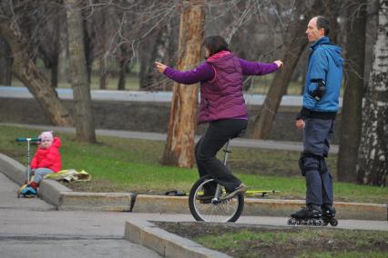 Москва. Женщина на уницикле и мужчина на роликах.