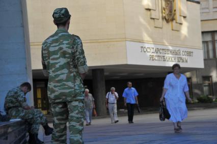 Симферополь. Мужчины в военной форме с нашивкой `Вежливые люди` у здания Государственного Совета Республики Крым.