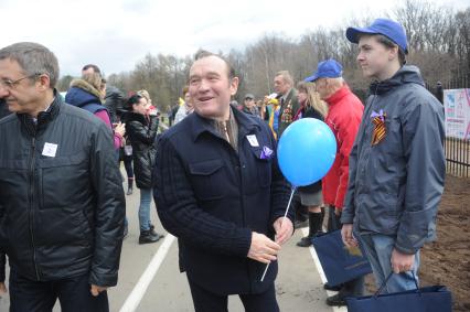 Заместитель мэра Москвы по вопросам ЖКХ Петр Бирюков (в центре) во время акции `Сирень Победы` в Ботаническом саду в Москве .